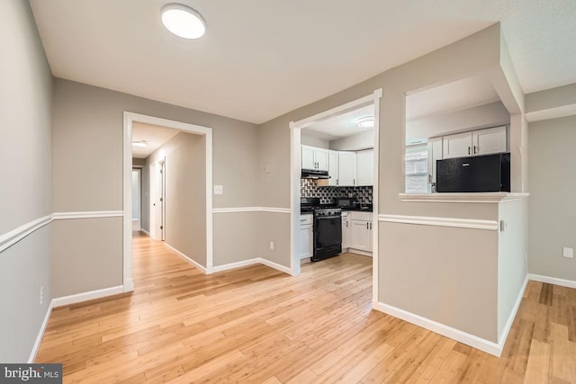 11921 Tarragon Rd Unit F, Reisterstown, MD 21136 - kitchen featuring range with gas cooktop, fridge, under cabinet range hood, white cabinetry, and light wood-style floors