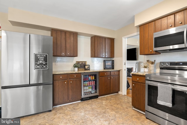 1965 Niagara Ln, York, PA 17408 - kitchen featuring stainless steel appliances, beverage cooler, tasteful backsplash, light stone countertops, and a fireplace