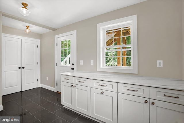 3722 13th St NE, Washington, DC 20017 - kitchen with light stone counters, white cabinetry, and dark tile patterned floors