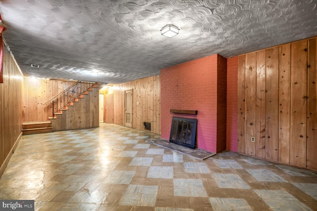 4901 Ashby St NW, Washington, DC 20007 - finished below grade area featuring wood walls, tile patterned floors, stairs, and a brick fireplace