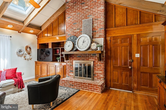 707 Pheasant Run, Kennett Square, PA 19348 - living area featuring a skylight, wood finished floors, beamed ceiling, a brick fireplace, and high vaulted ceiling