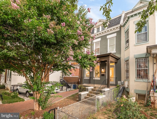 1371 Perry Pl NW, Washington, DC 20010 - view of front facade featuring mansard roof, a fenced front yard, and brick siding