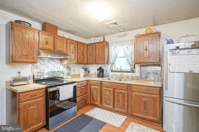 16 Pin Oak Dr, Atco, NJ 08004 - kitchen with stainless steel appliances, under cabinet range hood, light countertops, light wood-style floors, and a textured ceiling