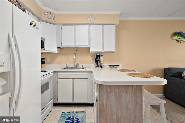 778 94th St Unit 205, Ocean City, MD 21842 - kitchen featuring white appliances, a peninsula, ornamental molding, a kitchen breakfast bar, and light countertops