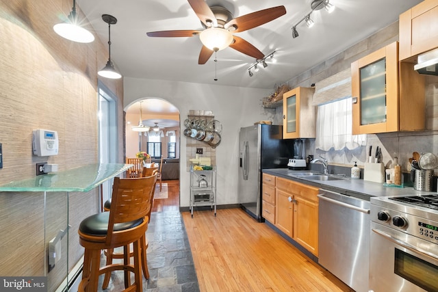 2515 17th St NE, Washington, DC 20018 - kitchen with appliances with stainless steel finishes, ceiling fan, dark countertops, rail lighting, and glass insert cabinets