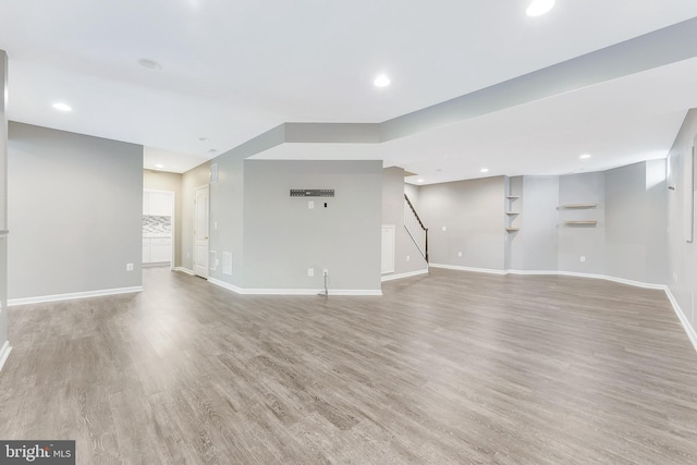 20152 Boxwood Pl, Ashburn, VA 20147 - unfurnished living room with light wood-type flooring, stairway, and recessed lighting