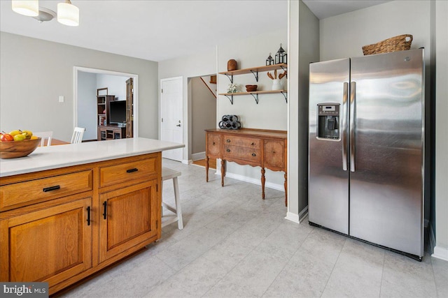 8 High Acres Dr, Ewing, NJ 08628 - kitchen featuring stainless steel fridge, brown cabinetry, light countertops, and a kitchen bar
