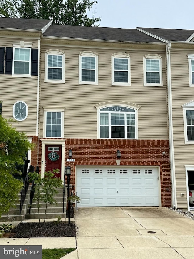 1221 Orchid Rd, Gambrills, MD 21054 - townhome / multi-family property featuring an attached garage, driveway, and brick siding