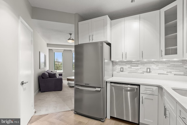 955 26th St NW Unit 510, Washington, DC 20037 - kitchen with stainless steel appliances, light countertops, glass insert cabinets, and decorative backsplash