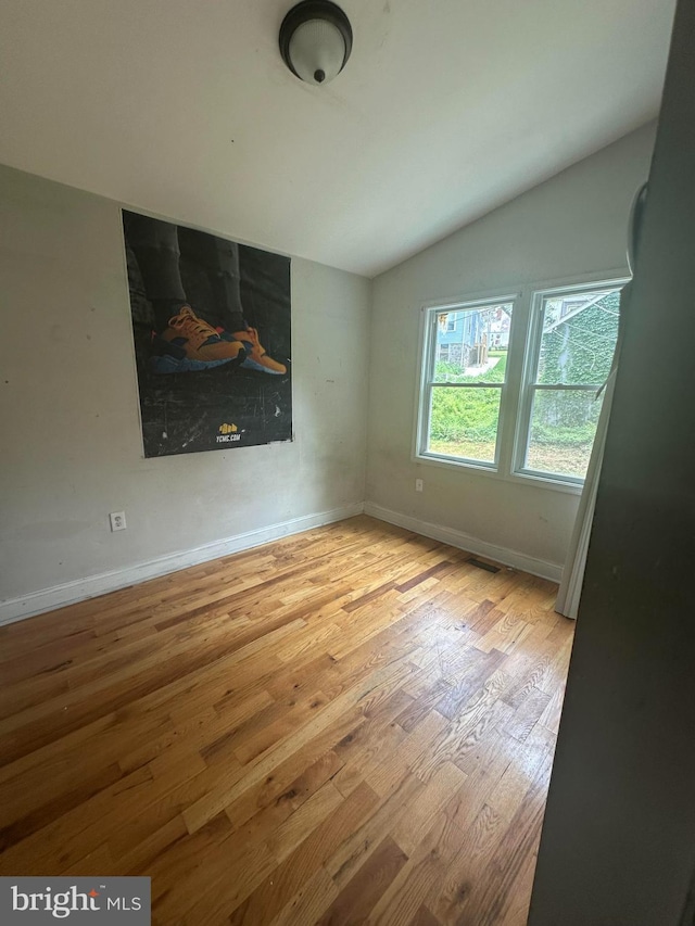 3709 Chesholm Rd, Baltimore, MD 21216 - unfurnished room with vaulted ceiling and wood finished floors