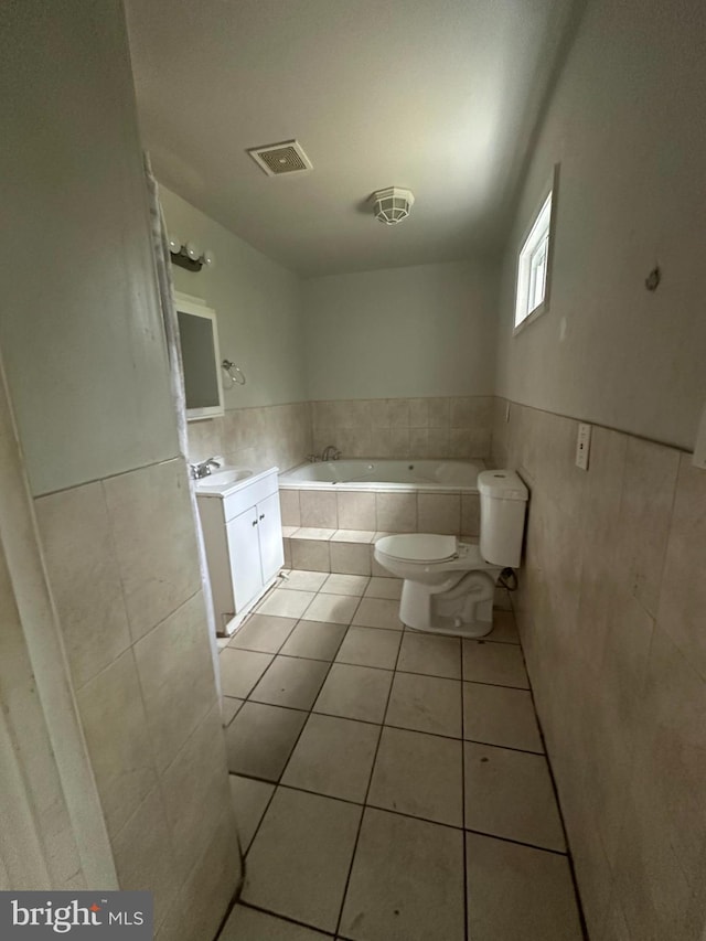 3709 Chesholm Rd, Baltimore, MD 21216 - bathroom featuring tile patterned floors, tiled bath, vanity, a wainscoted wall, and tile walls