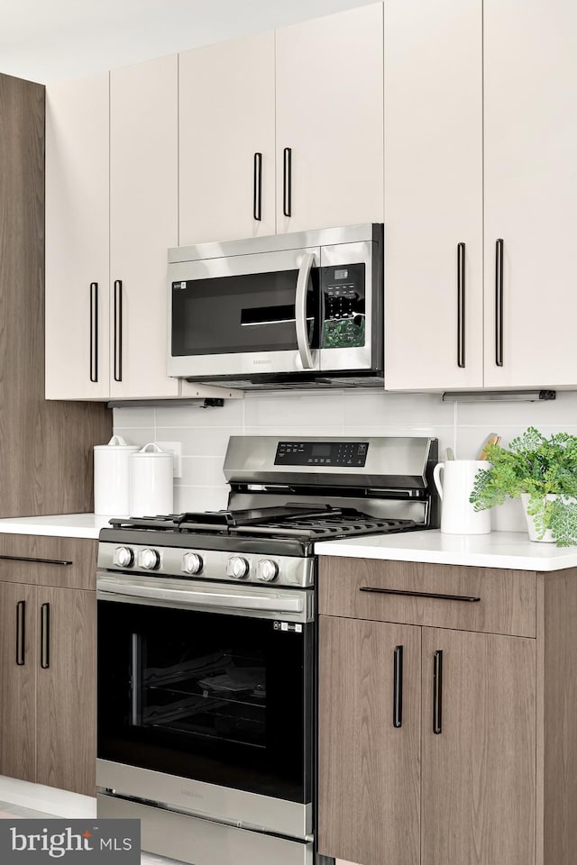 3934 14th St NW Unit 102, Washington, DC 20011 - kitchen featuring stainless steel appliances, tasteful backsplash, light countertops, and modern cabinets
