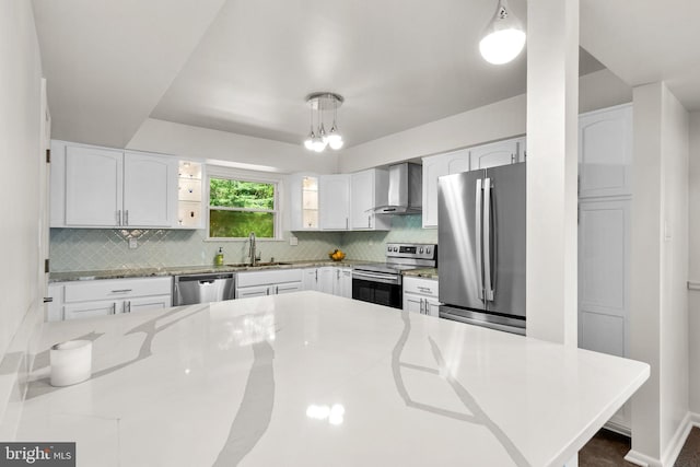 52 Anna Ct Unit 275, Gaithersburg, MD 20877 - kitchen featuring appliances with stainless steel finishes, wall chimney exhaust hood, tasteful backsplash, white cabinetry, and hanging light fixtures
