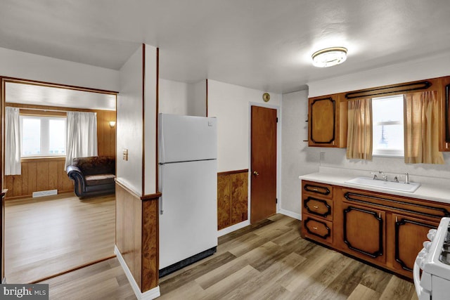 3533 Chestnut St, Reading, PA 19605 - kitchen featuring freestanding refrigerator, light wood-style flooring, light countertops, stove, and brown cabinets