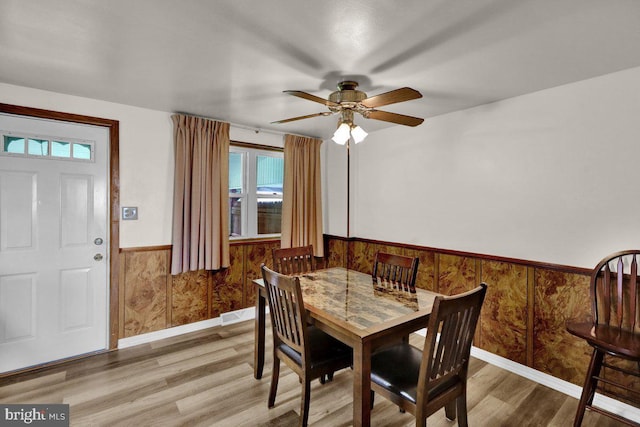 3533 Chestnut St, Reading, PA 19605 - dining room with wainscoting, wood finished floors, a ceiling fan, and wooden walls