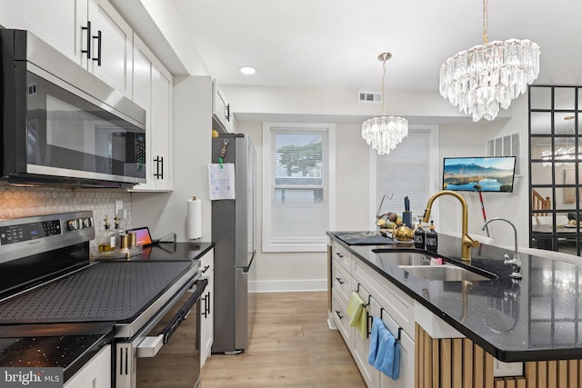 531 Redfern St, Hamilton, NJ 08610 - kitchen with appliances with stainless steel finishes, a chandelier, light wood-style floors, tasteful backsplash, and pendant lighting