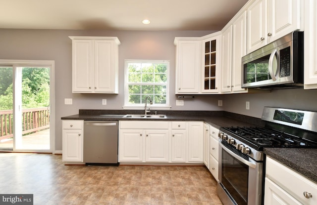 1007 Wright Ct, Fredericksburg, VA 22401 - kitchen featuring stainless steel appliances, dark countertops, white cabinetry, recessed lighting, and glass insert cabinets