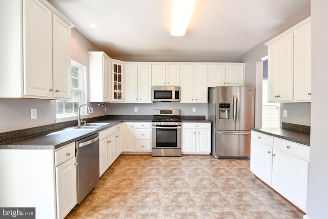 1007 Wright Ct, Fredericksburg, VA 22401 - kitchen featuring appliances with stainless steel finishes, dark countertops, glass insert cabinets, and white cabinets