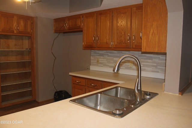 kitchen with backsplash, hardwood / wood-style flooring, and sink