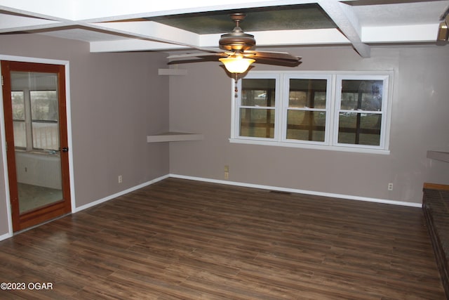 empty room with dark hardwood / wood-style floors, beam ceiling, coffered ceiling, and ceiling fan