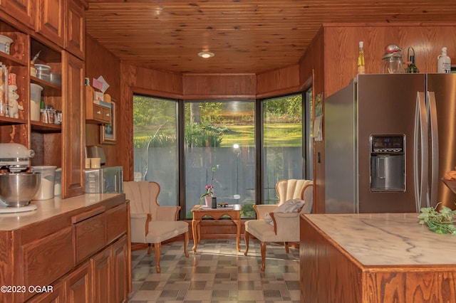 tiled dining area featuring wood ceiling and wood walls