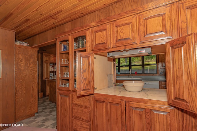 kitchen featuring white dishwasher, light tile floors, and sink