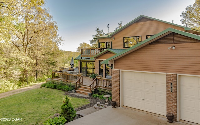 view of front of property with a deck, a front lawn, and a garage