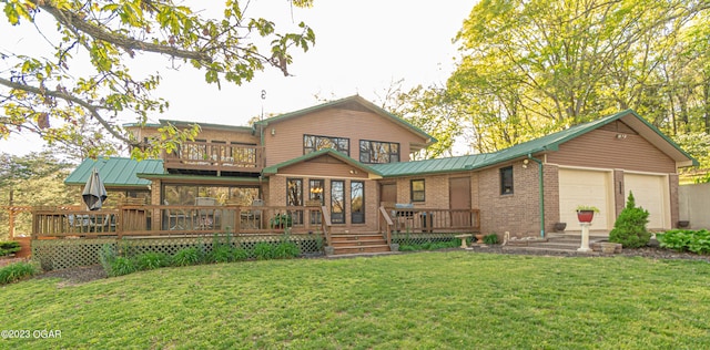 rear view of house featuring a deck, a lawn, and a garage