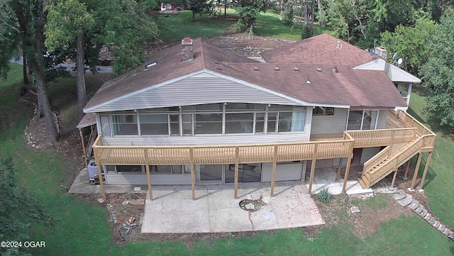 rear view of property with a deck, a patio, and a sunroom