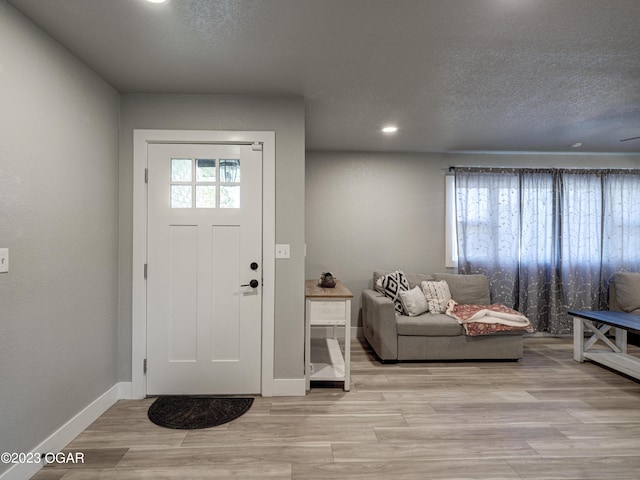 entrance foyer with a textured ceiling and light wood-type flooring