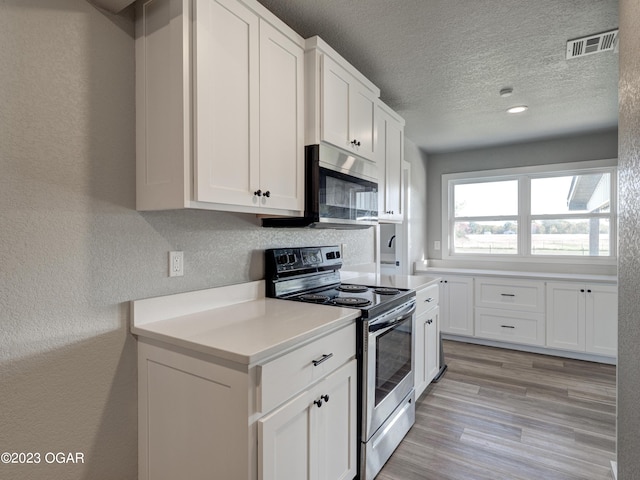 kitchen featuring tasteful backsplash, white cabinetry, light hardwood / wood-style flooring, a textured ceiling, and electric range oven