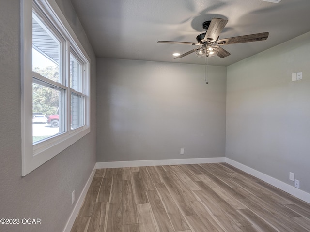 unfurnished room with a healthy amount of sunlight, ceiling fan, and hardwood / wood-style flooring