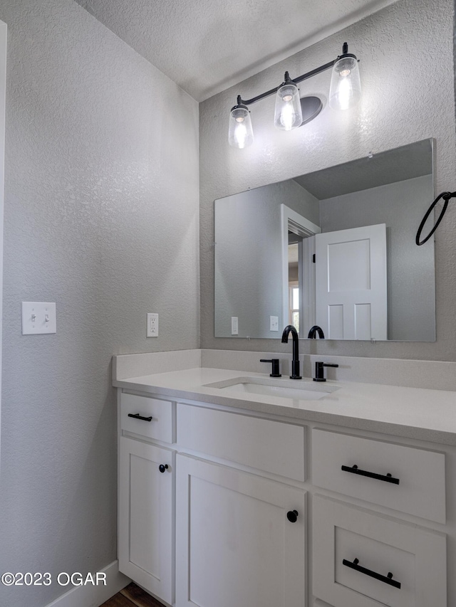 bathroom with a textured ceiling and vanity