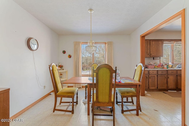 dining space with light tile flooring, a notable chandelier, and a wealth of natural light