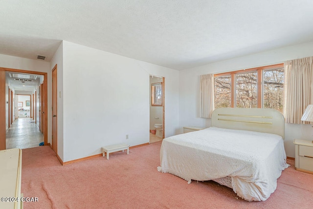 bedroom featuring light colored carpet and ensuite bathroom