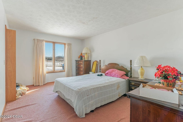 bedroom featuring light colored carpet and a textured ceiling