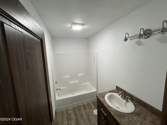 bathroom featuring vanity, bathtub / shower combination, and wood-type flooring