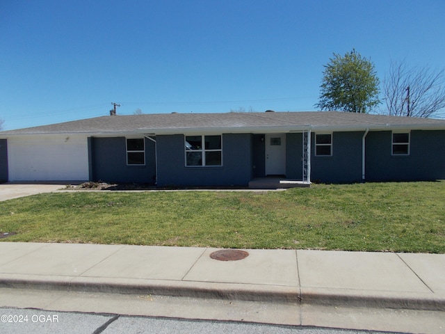 ranch-style house with a garage and a front lawn