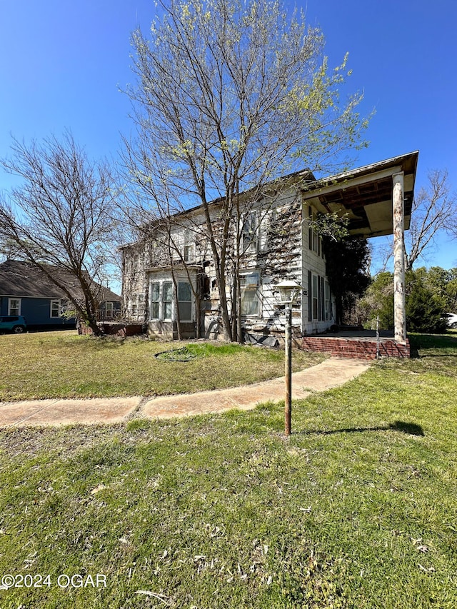 rear view of property featuring a lawn