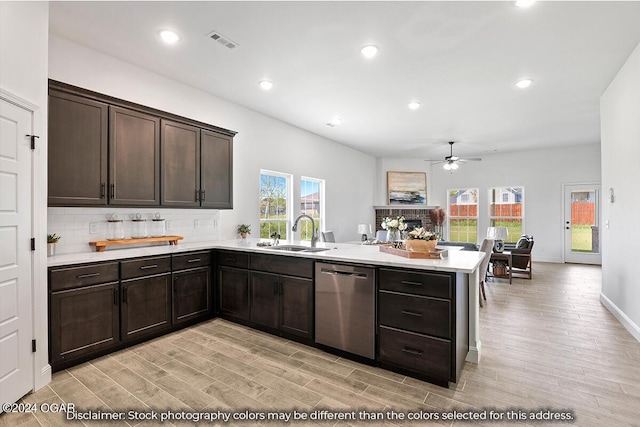 kitchen with a healthy amount of sunlight, stainless steel dishwasher, dark brown cabinetry, and sink