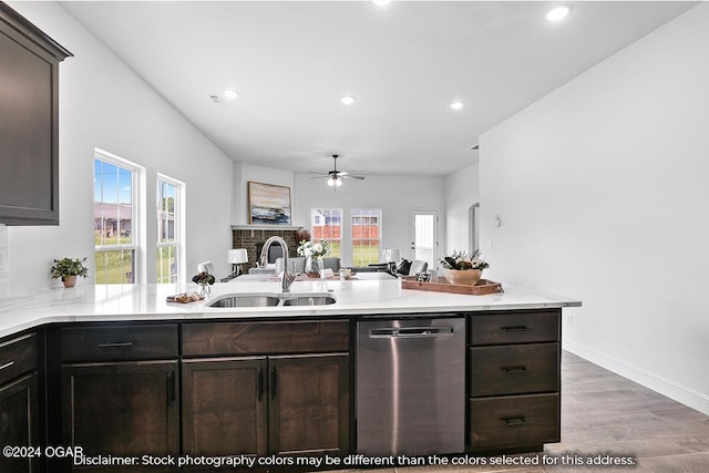 kitchen with kitchen peninsula, dishwasher, sink, and light hardwood / wood-style flooring