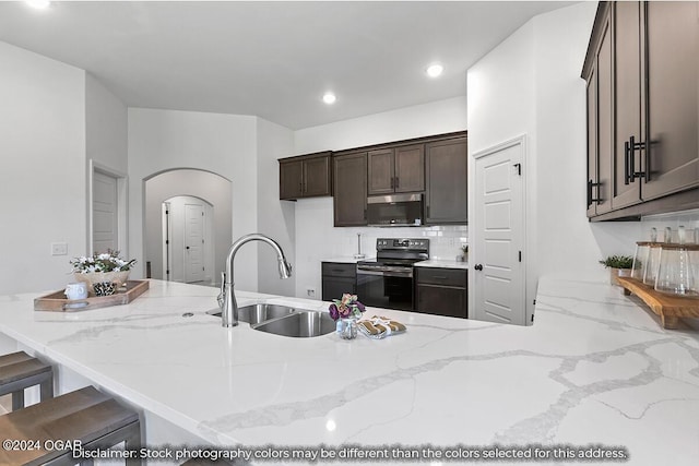 kitchen featuring a breakfast bar area, light stone countertops, sink, and stainless steel appliances