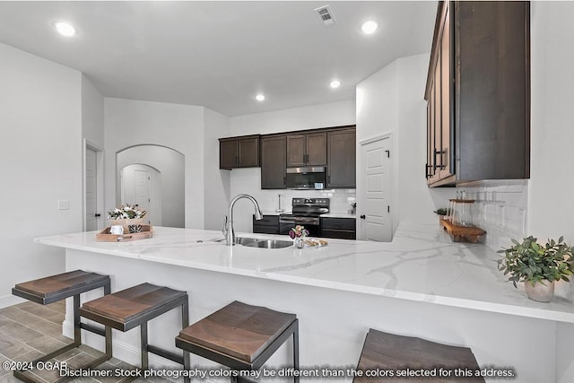 kitchen with decorative backsplash, black electric range, and kitchen peninsula