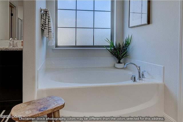 bathroom featuring sink and a bath to relax in