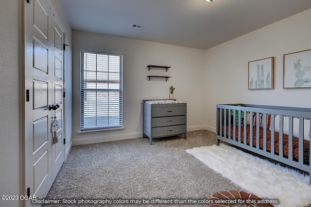 carpeted bedroom featuring a nursery area