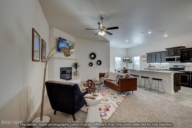 carpeted living room featuring ceiling fan and a brick fireplace