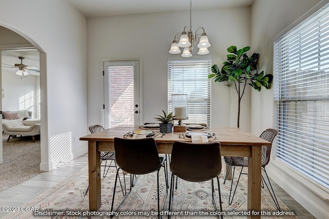 dining area featuring ceiling fan with notable chandelier, plenty of natural light, and light hardwood / wood-style flooring