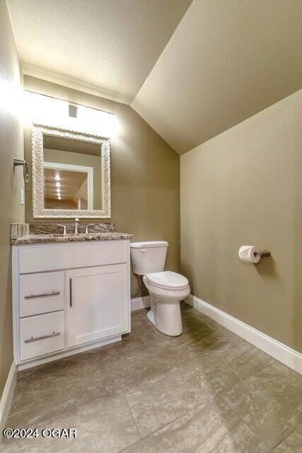 21942 Mill Creek Cir, Shell Knob, MO 65747 - bathroom featuring toilet, lofted ceiling, a textured ceiling, vanity, and tile floors