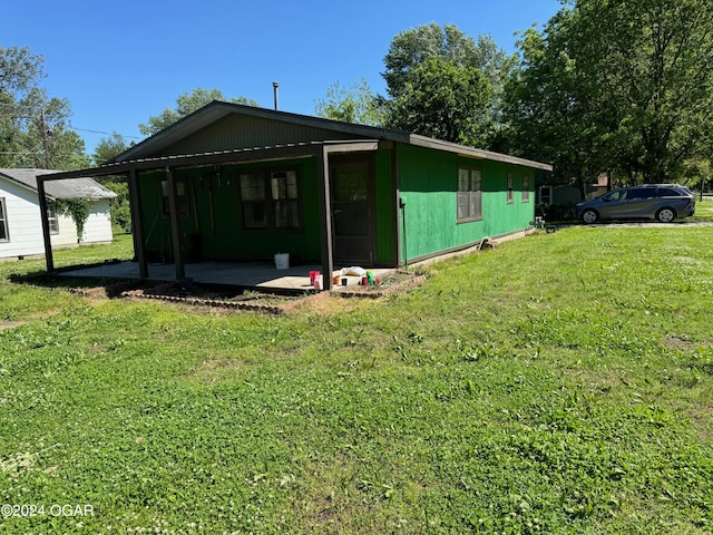 rear view of house featuring a lawn