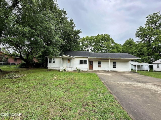 view of front facade with a carport, a porch, and a front lawn